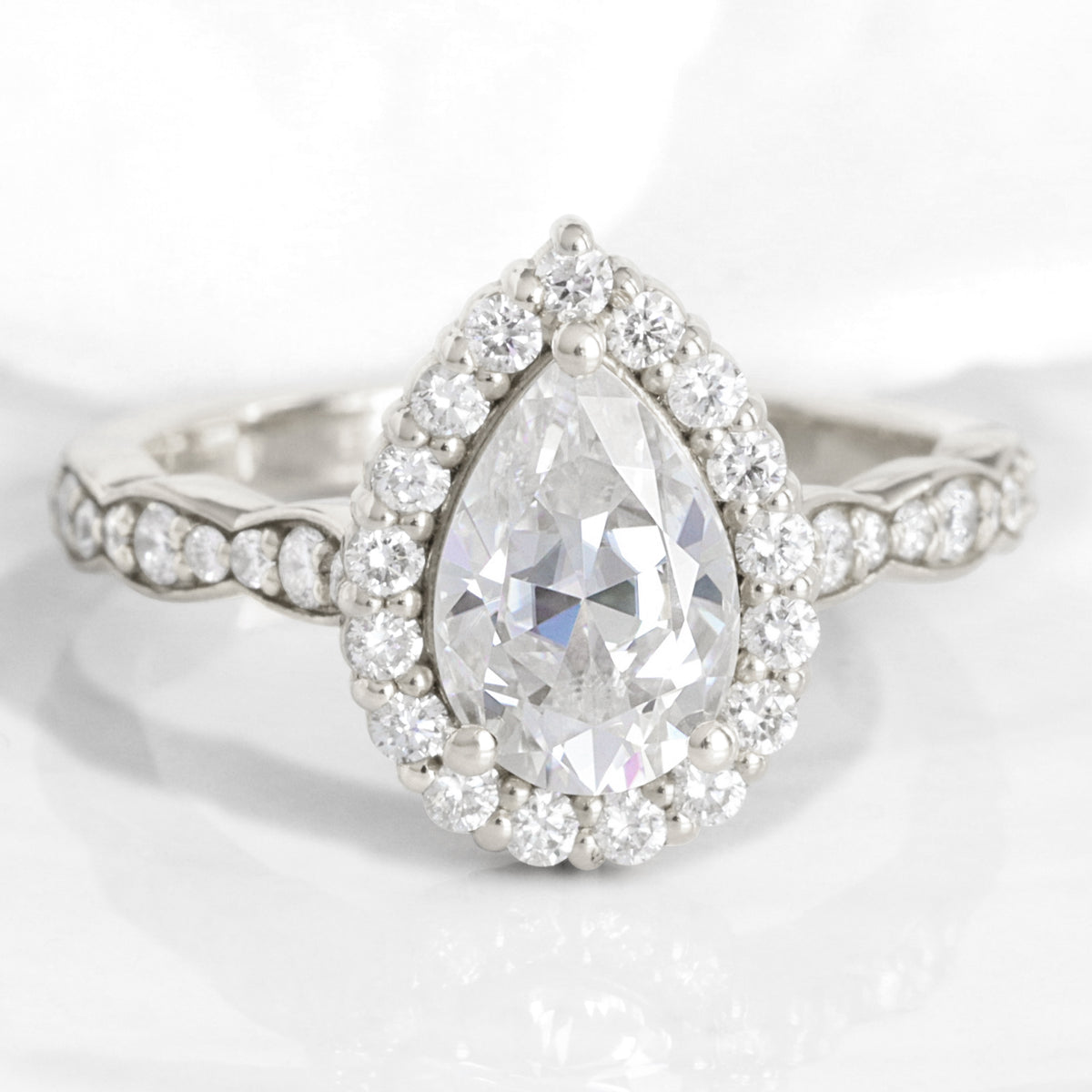 Halo diamond pear moissanite engagement ring in rose gold scalloped band by la more design