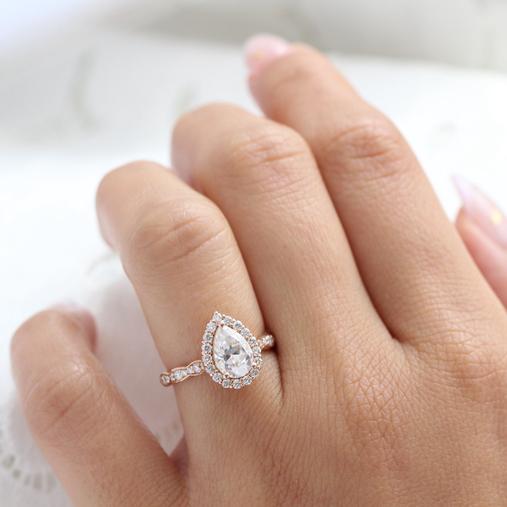 Halo diamond pear moissanite engagement ring in rose gold scalloped band by la more design
