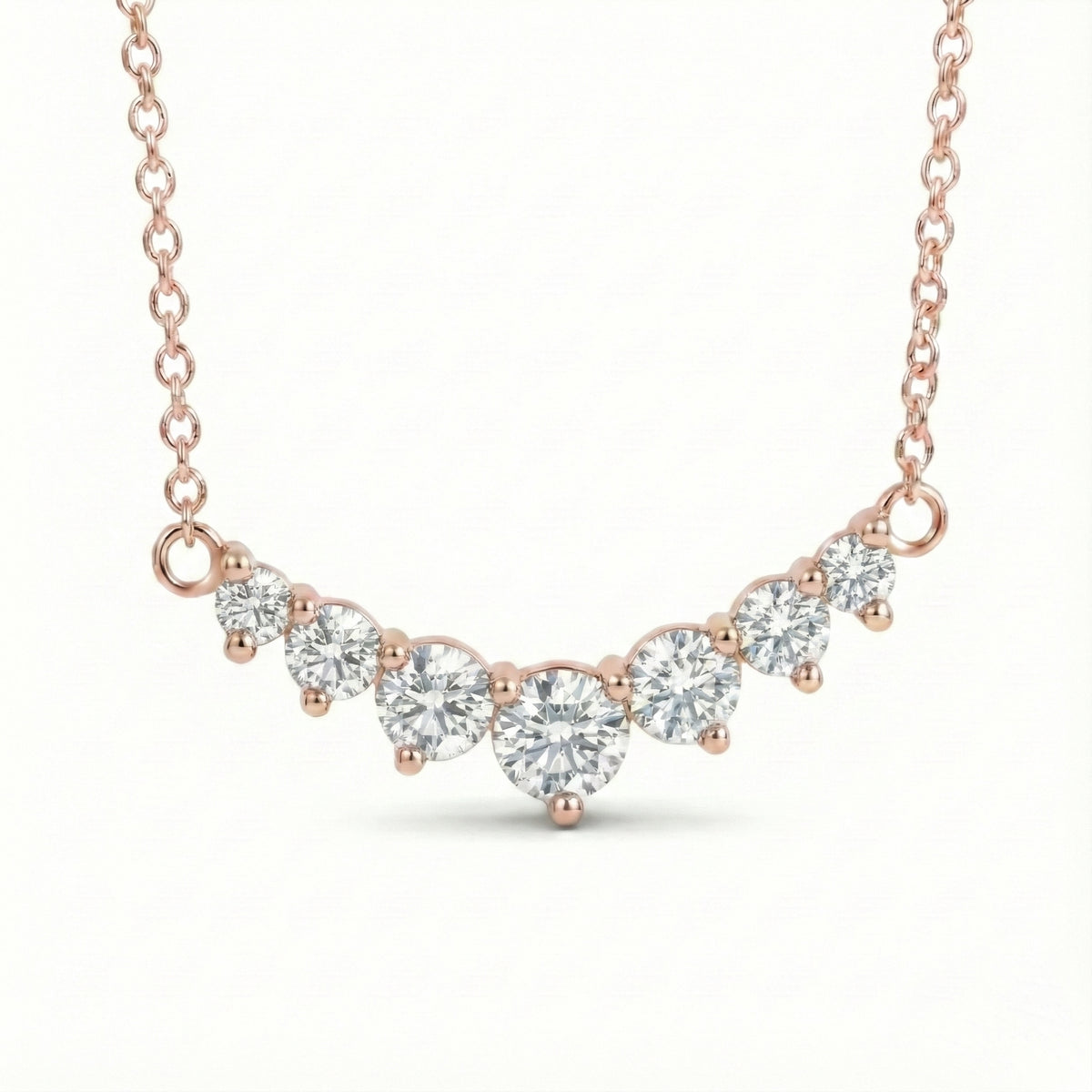 14k rose gold diamond arc necklace with 7 graduated round diamonds in a curved smile setting pendant la more design jewelry