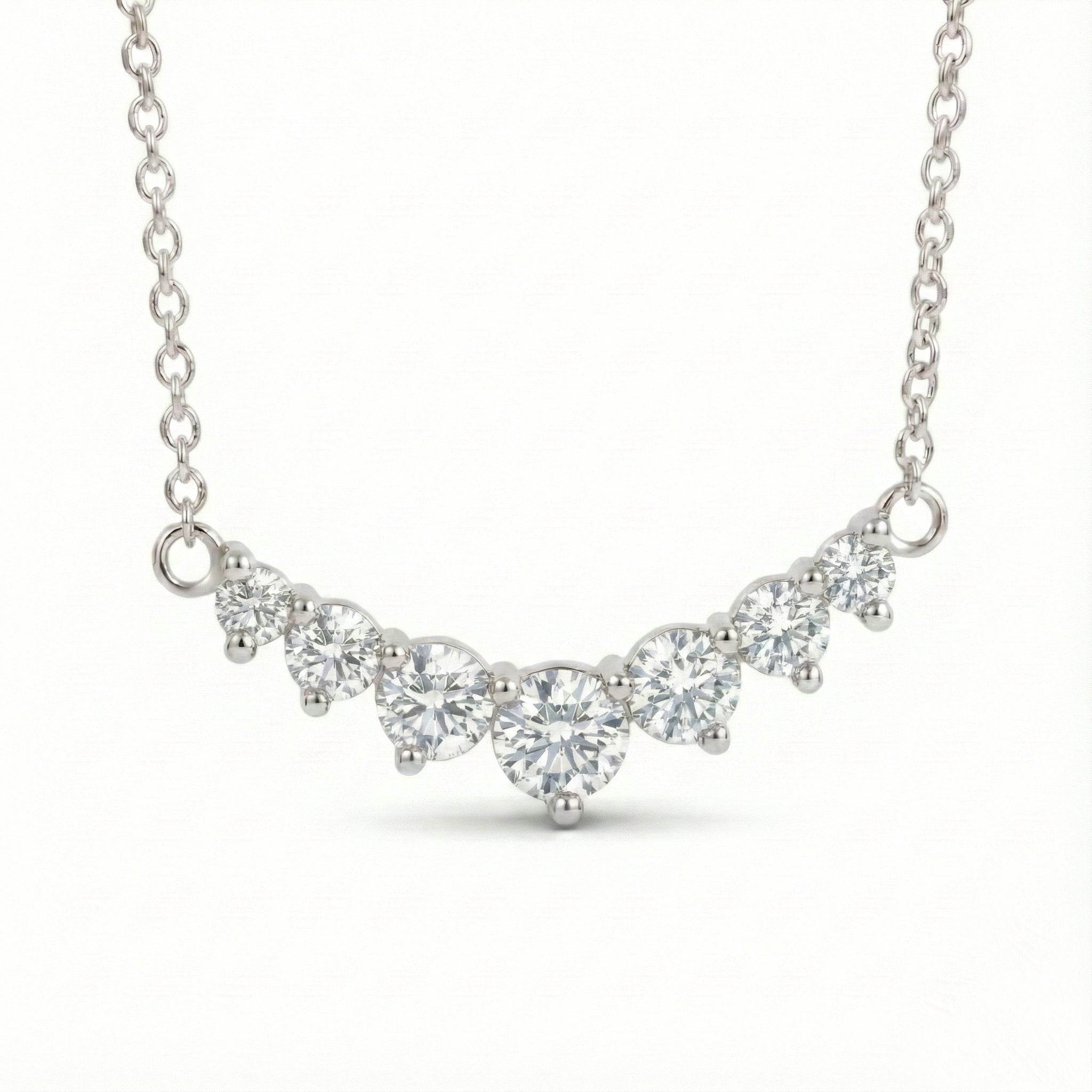 14k white gold diamond arc necklace with 7 graduated round diamonds in a curved smile setting pendant la more design jewelry