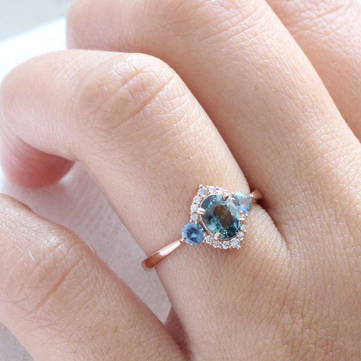 Unique teal blue sapphire ring rose gold diamond halo 3 stone ring la more design jewelry