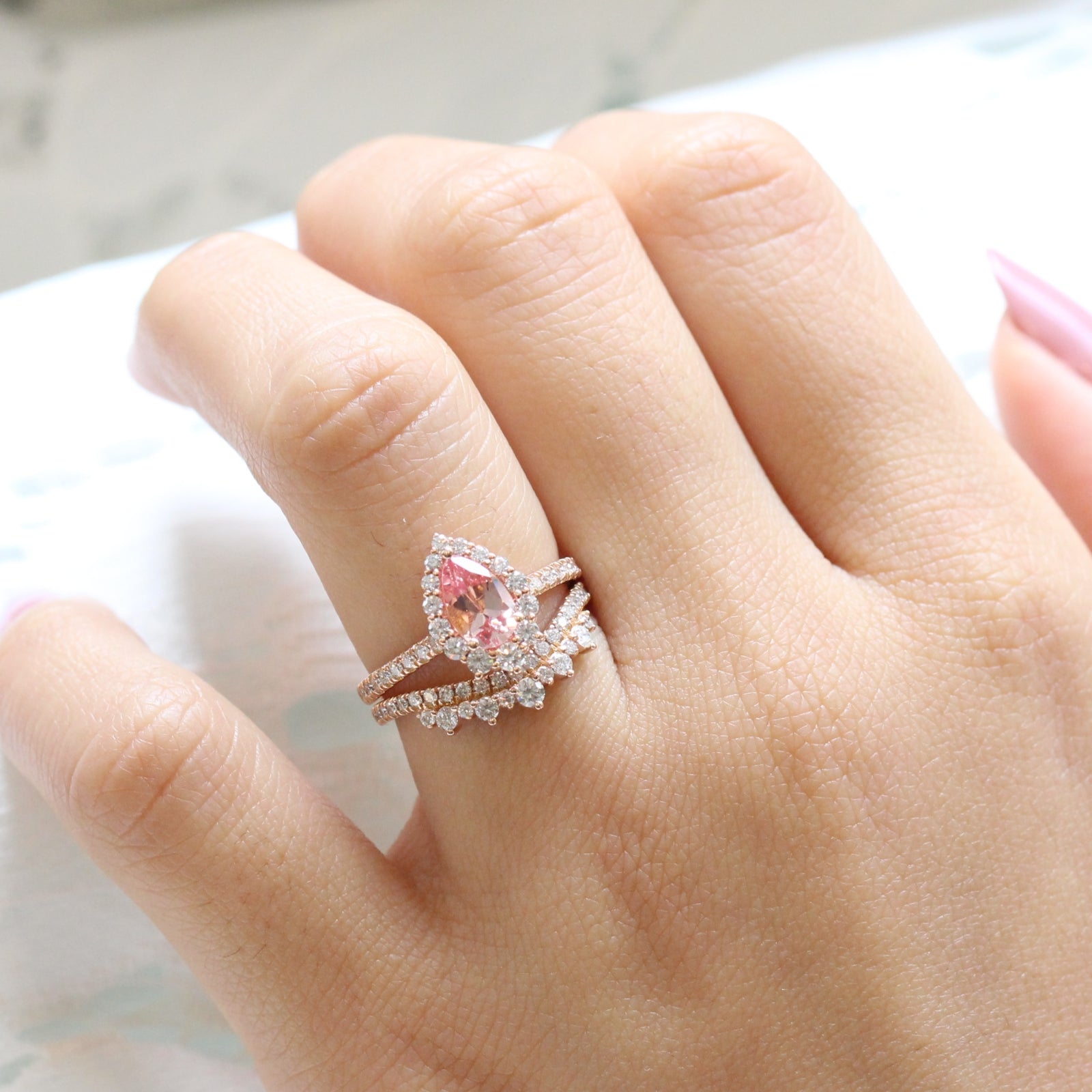 pear shaped peach sapphire engagement ring rose gold and curved crown diamond wedding band by la more design jewelry