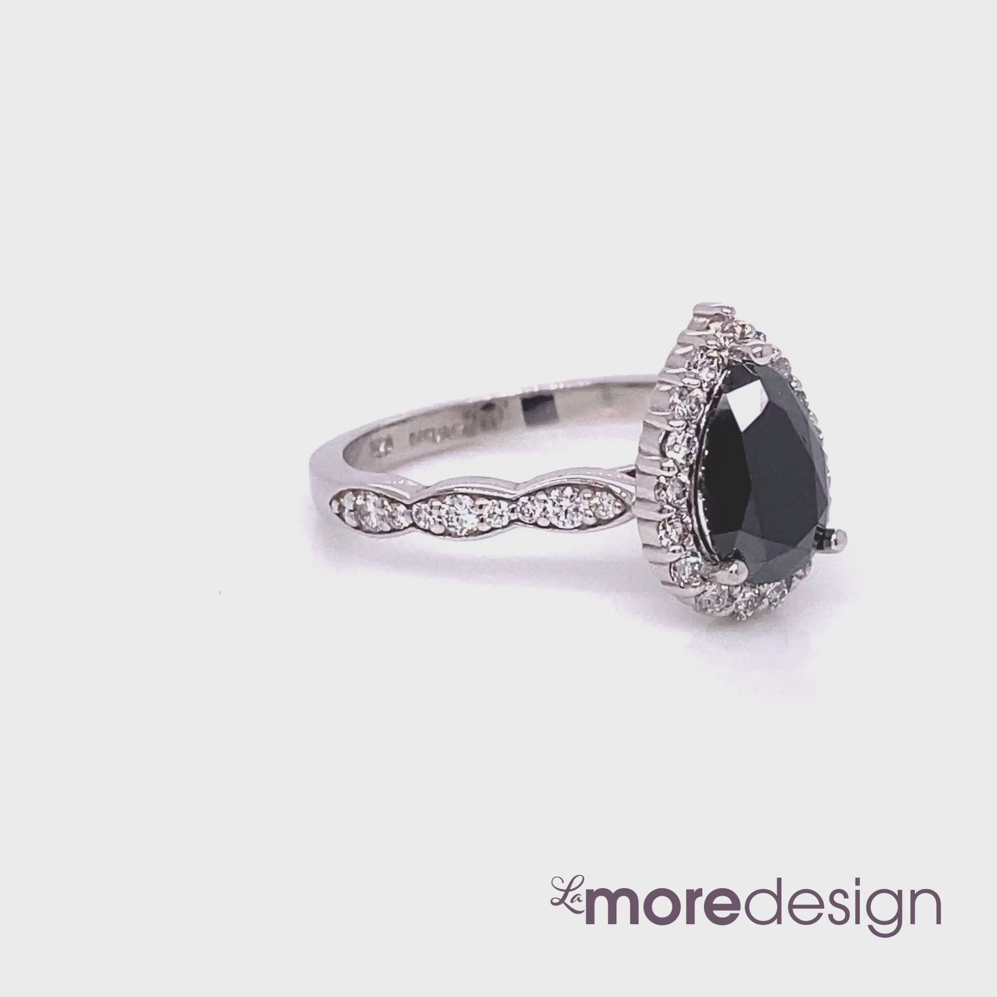 Stunningly gorgeous black diamond engagement ring features a 9x6mm natural pear cut black diamond surrounded by round brilliant white diamonds set in 14k white gold halo diamond ring setting and finished in a scalloped diamond band to add extra sparkles to this beautiful halo diamond pear engagement ring. 
