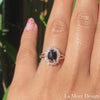 Vintage inspired rose cut black diamond engagement ring in the split shank is crafted in 14k rose gold vintage luna halo ring setting graced with an 8x6mm oval-shaped rose cut black diamond center surrounded by brilliant white diamonds. The distinctive yet elegant look of this rose cut diamond ring will make your engagement unforgettable! It can be made in your choice of platinum or 14k or 18k yellow, rose, or white gold. A matching bridal ring set is available. 