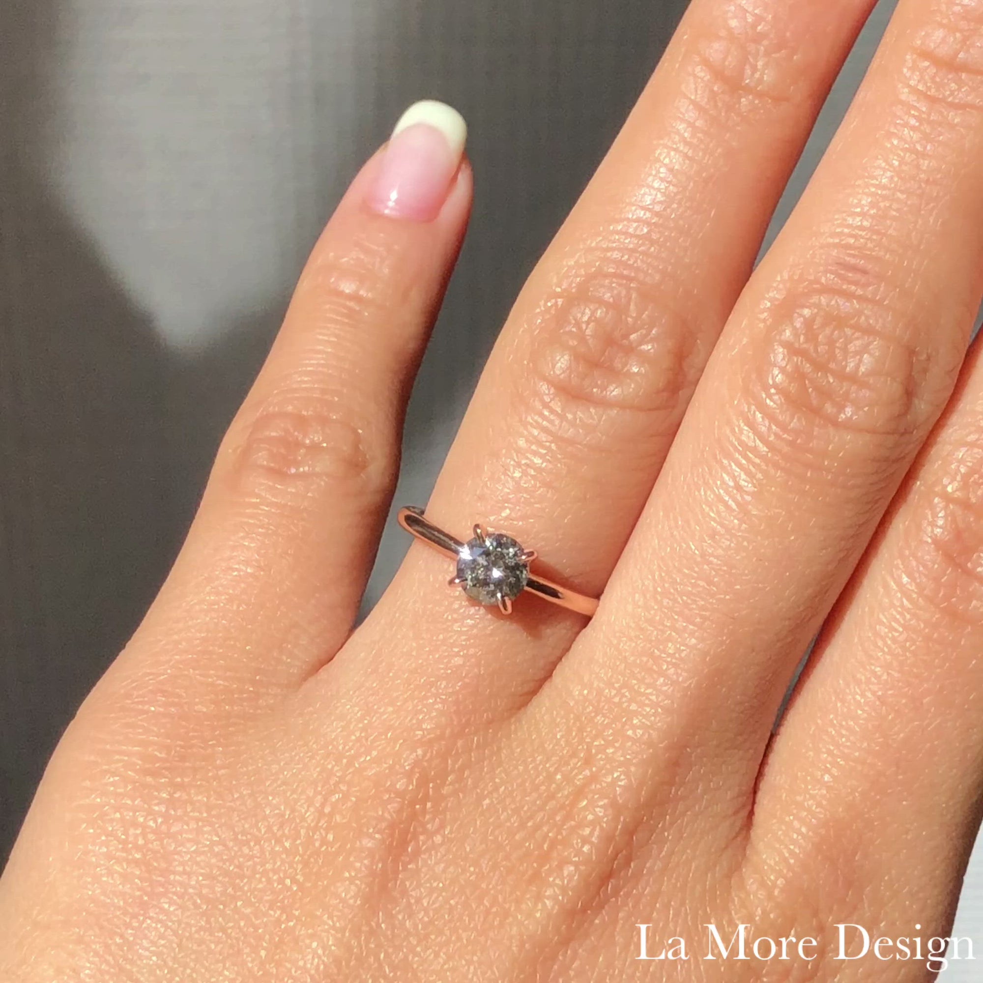 This stunningly gorgeous grey diamond engagement ring features a 1.02 carat round cut natural salt and pepper diamond set in a 14k rose gold flat set low profile solitaire ring setting that lays flat perfectly on top of your finger for comfortable wear. Adore your loved one with this one-carat diamond ring!