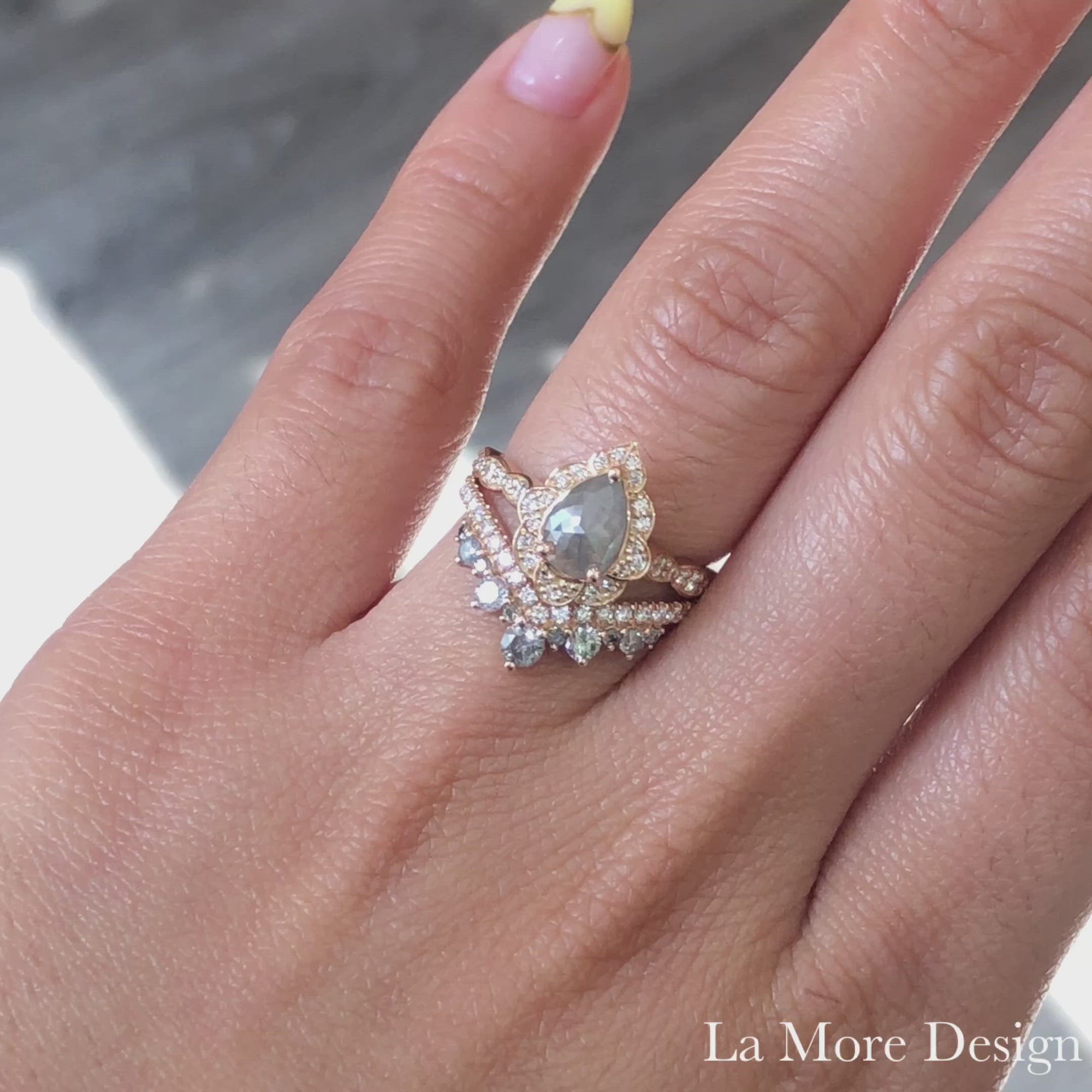 Breathtakingly one of a kind creation! This unique grey diamond bridal set features a pear salt and pepper diamond engagement ring in 14k rose gold vintage floral diamond ring setting with an a 0.81 carat pear cut natural grey diamond center. For a gorgeous effect, a curved large tiara grey and white diamond wedding band is created to be paired with this vintage-inspired grey diamond engagement ring. This salt and pepper grey diamond wedding set is perfect for brides looking for a one-of-a-kind diamond ring