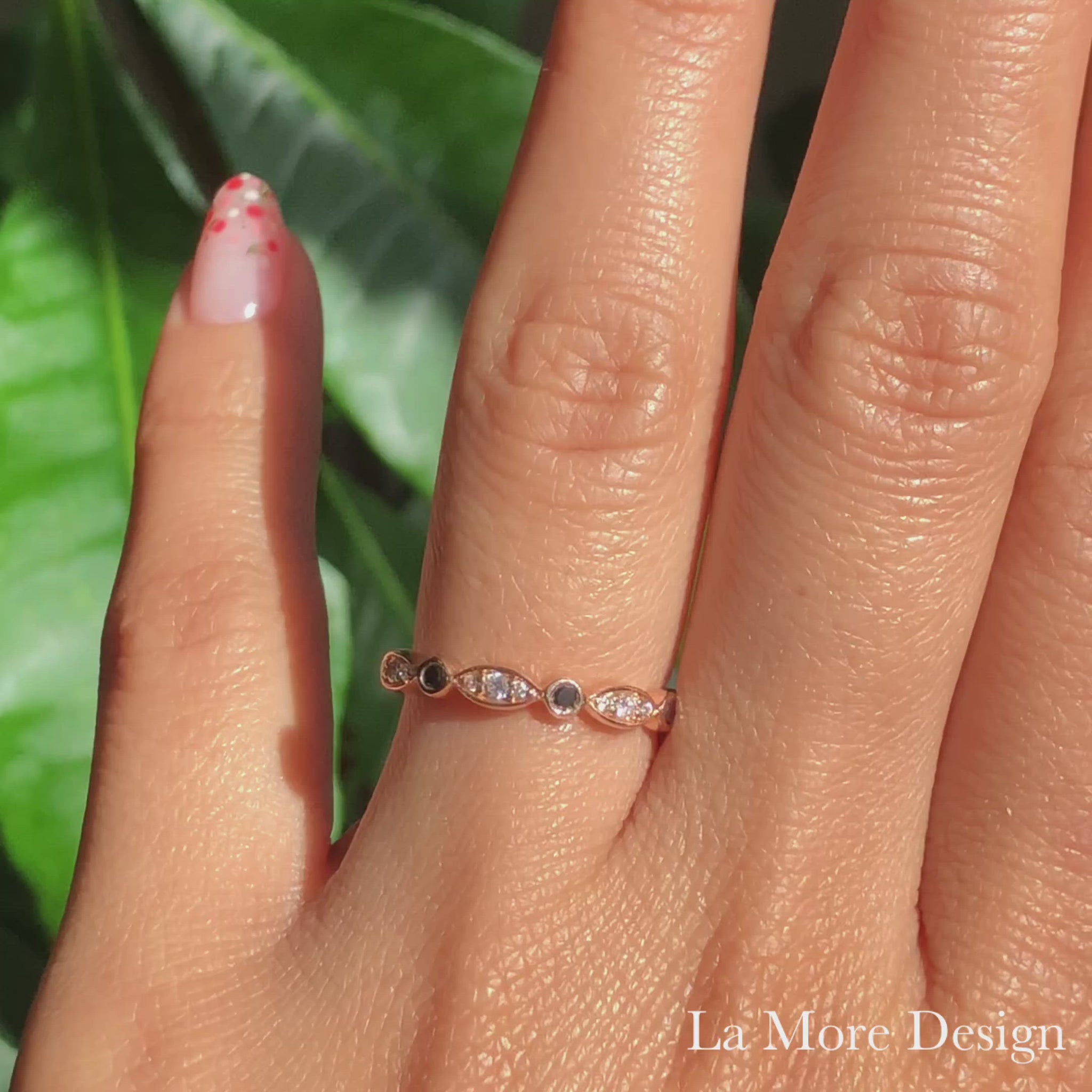This unique wedding band features alternating round and marquise-shaped frames studded with dazzling black and white diamonds set in 14k rose gold. The delicate scalloped design makes this diamond ring perfect to be paired with most of our engagement rings or also can be worn alone or in a stack. It can be made in your choice of platinum or 18k or 14k yellow, rose, or white gold.