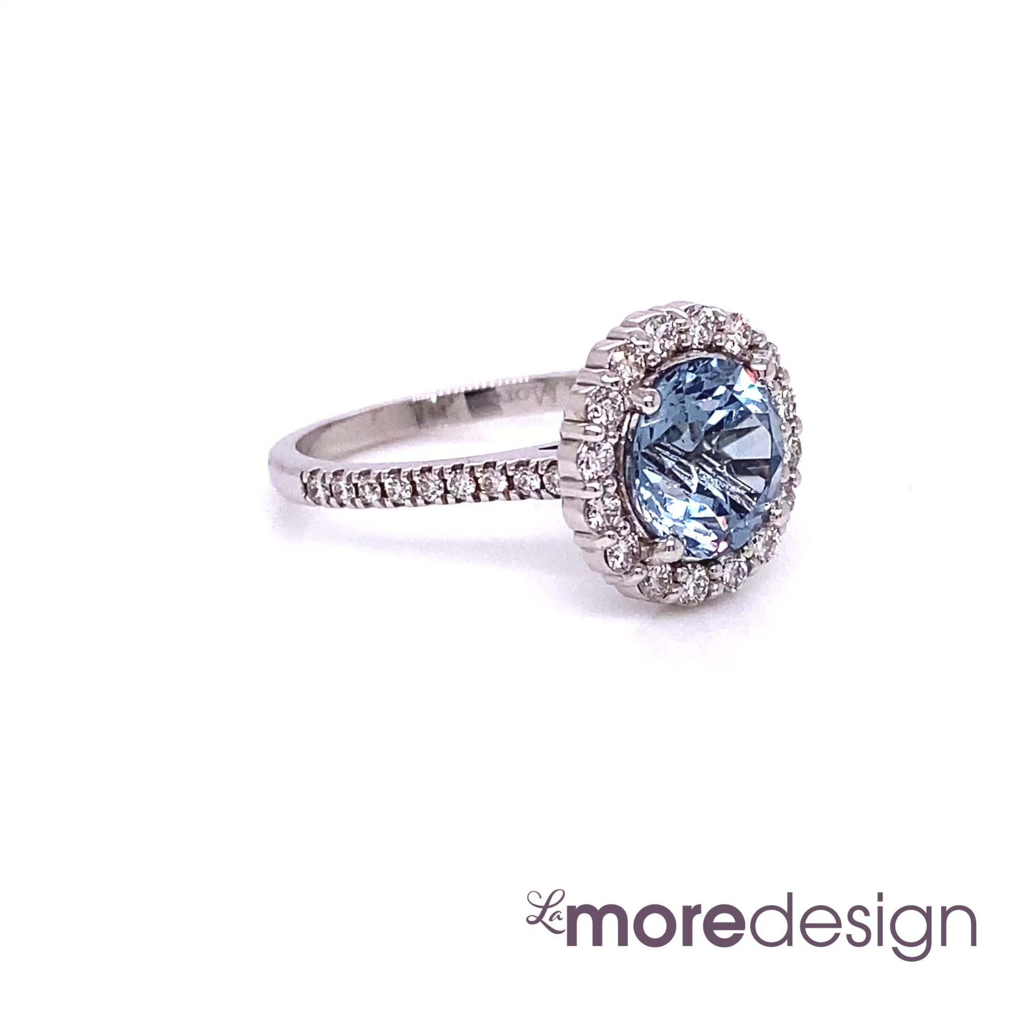 This exquisite sapphire ring features a large 2.84 carat round cut natural aqua blue sapphire set in a 18k white gold halo diamond ring setting and for a stunning effect, the ring shank is finished with pave diamonds ~ the total gemstone and diamond weight of the whole ring is 3.44 ct.tw.  This timelessly beautiful sapphire engagement ring will guarantee a big smile on your future bride's face! All our wedding bands can pair beautifully with this gorgeous halo diamond sapphire ring!