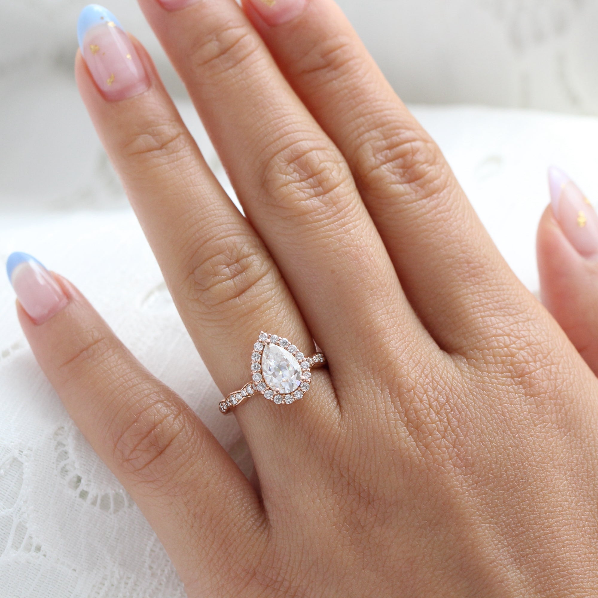 Halo diamond pear moissanite engagement ring in rose gold scalloped band by la more design