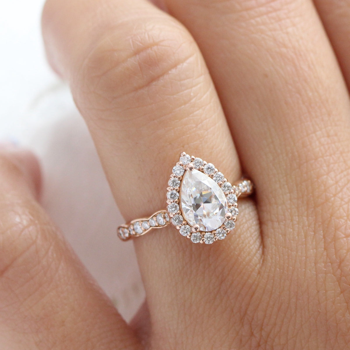 Halo diamond pear moissanite engagement ring in rose gold scalloped band by la more design