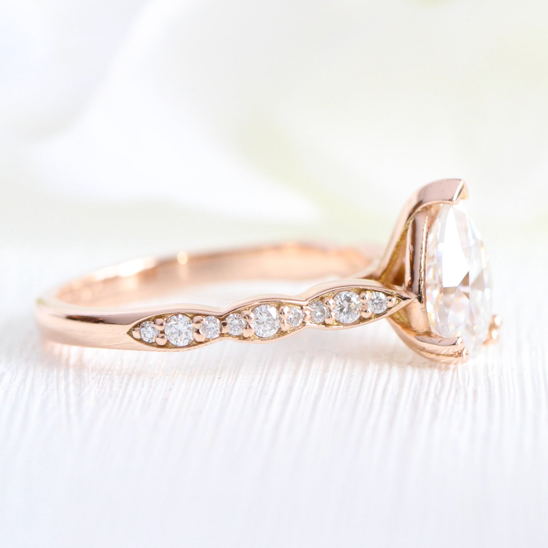 Solitaire pear moissanite engagement ring in rose gold scalloped diamond band by la more design jewelry