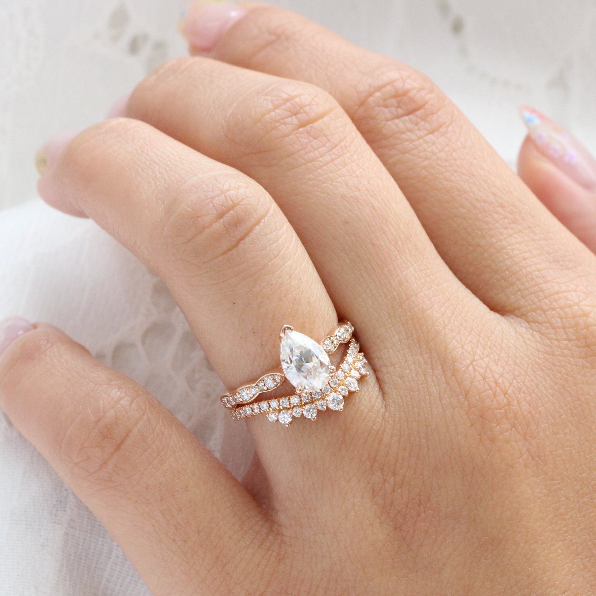 Solitaire pear moissanite ring and curved crown diamond wedding band in rose gold bridal set by la more design