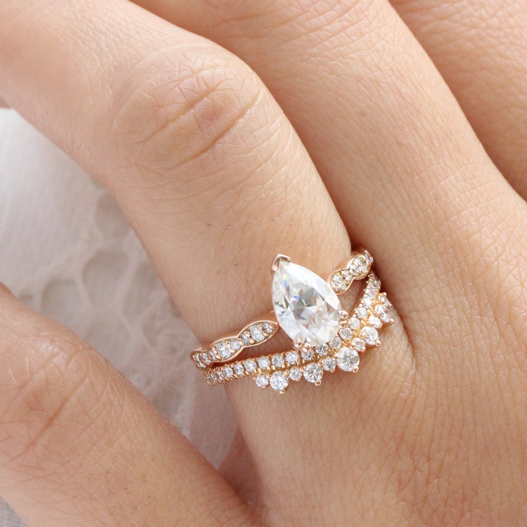 Solitaire pear moissanite ring and curved crown diamond wedding band in rose gold bridal set by la more design