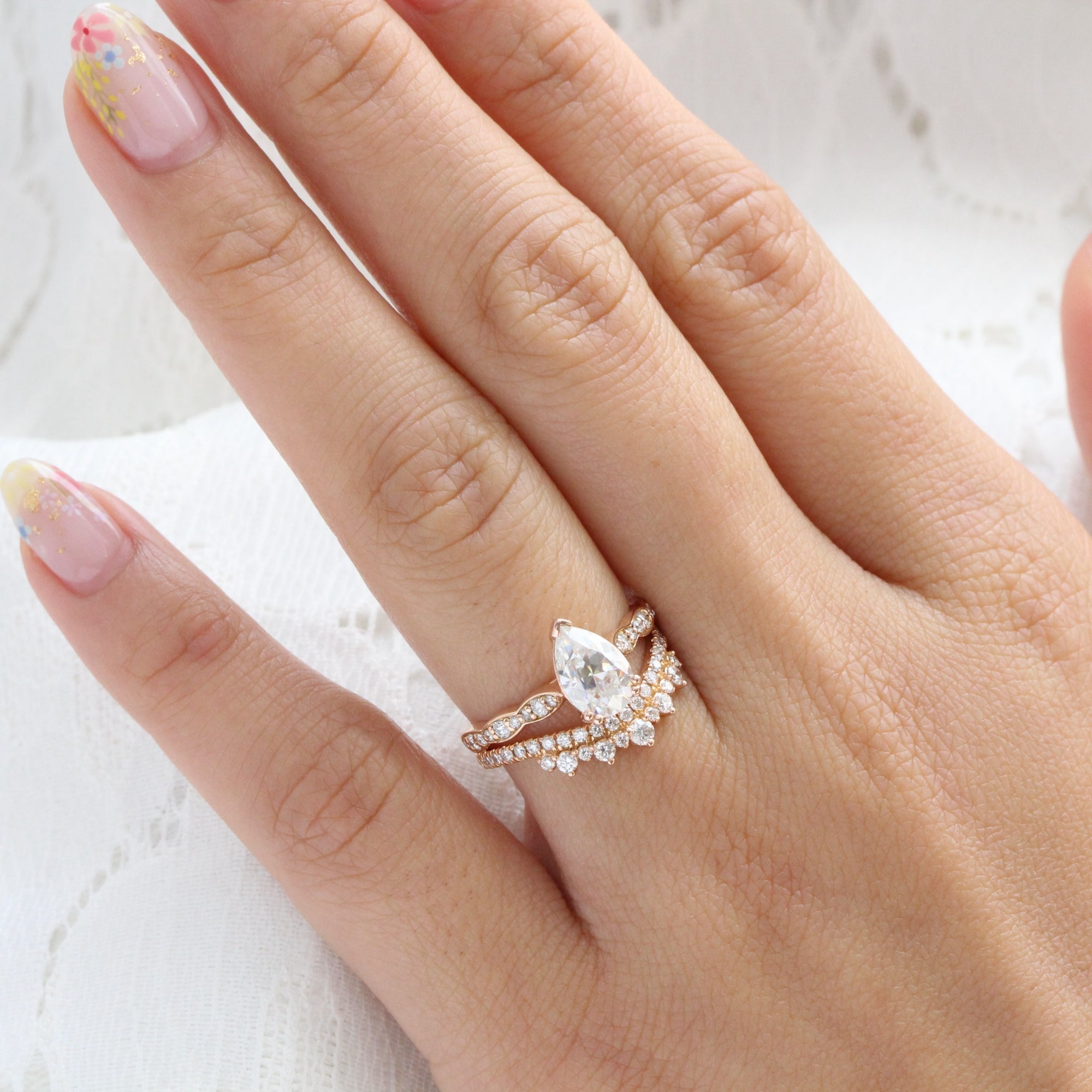Solitaire pear moissanite ring and curved crown diamond wedding band in rose gold bridal set by la more design