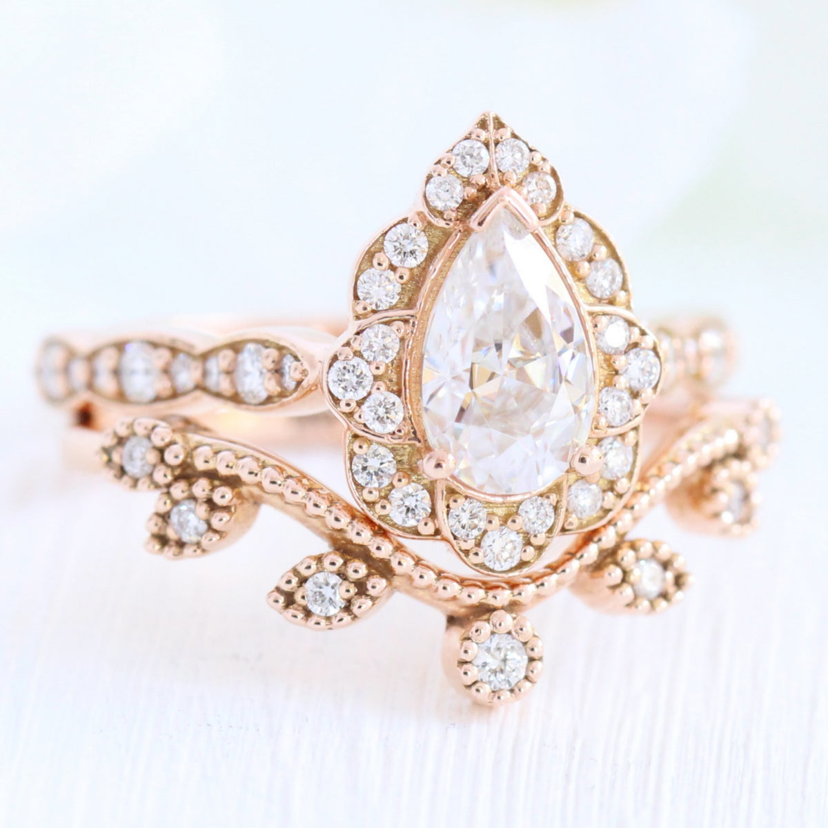Vintage floral pear moissanite ring bridal set and curved leaf diamond wedding band rose gold by la more design jewelry
