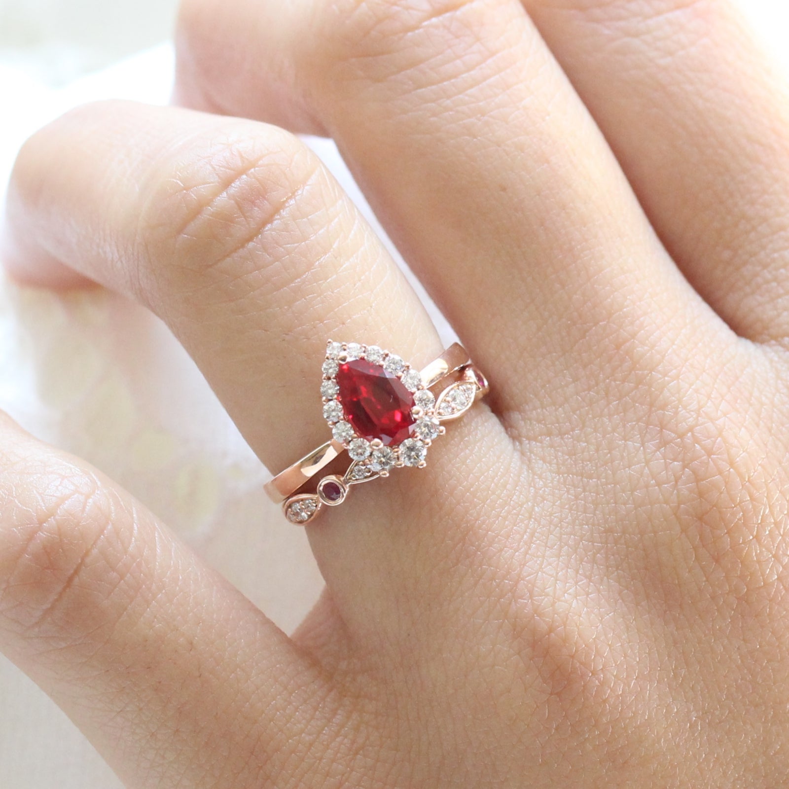 halo diamond ruby engagement ring rose gold pear shaped ring and diamond wedding band by la more design jewelry