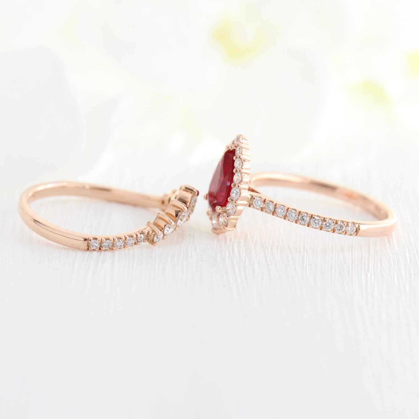 halo diamond ruby engagement ring rose gold pear shaped ring and pave diamond wedding band by la more design jewelry