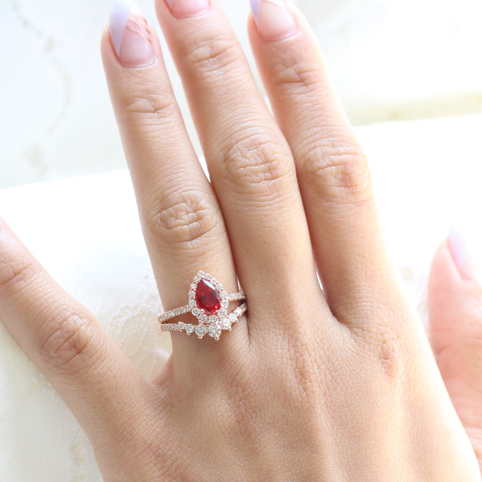 halo diamond ruby engagement ring rose gold pear shaped ring and pave diamond wedding band by la more design jewelry