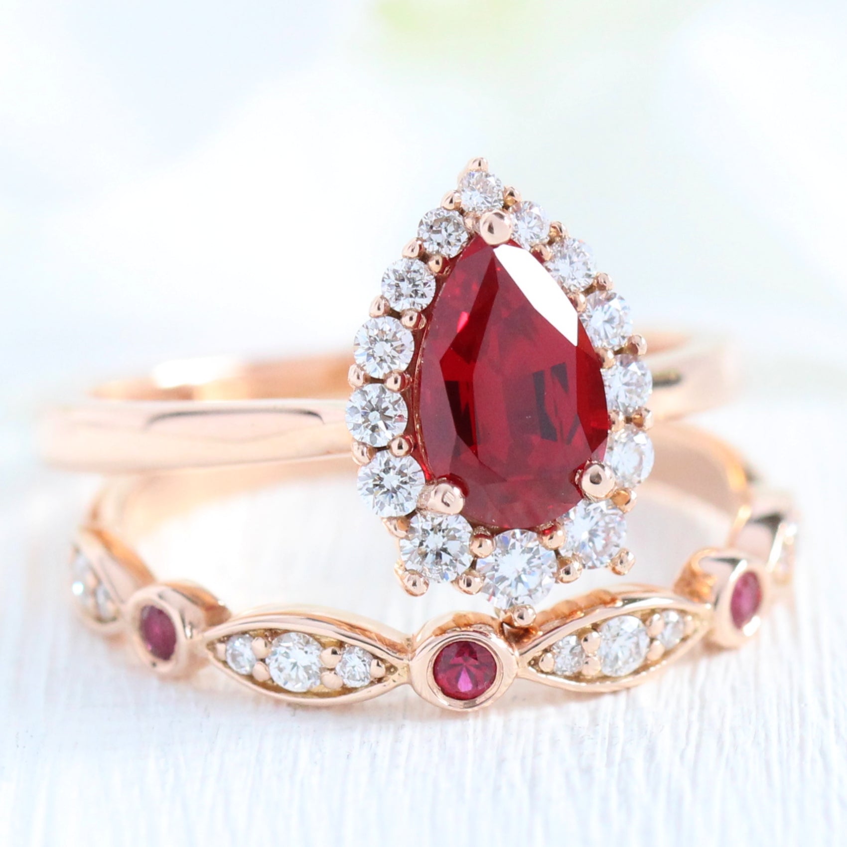 halo diamond ruby engagement ring rose gold pear shaped ring and diamond wedding band by la more design jewelry