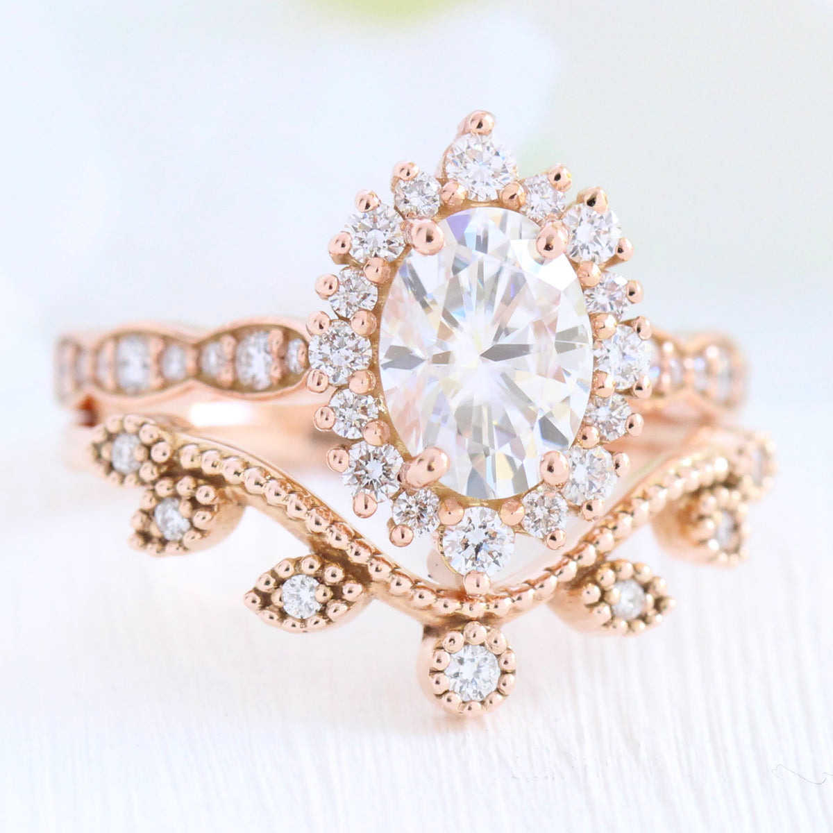 oval moissanite engagement ring rose gold halo diamond bridal set and leaf diamond wedding band by la more design jewelry
