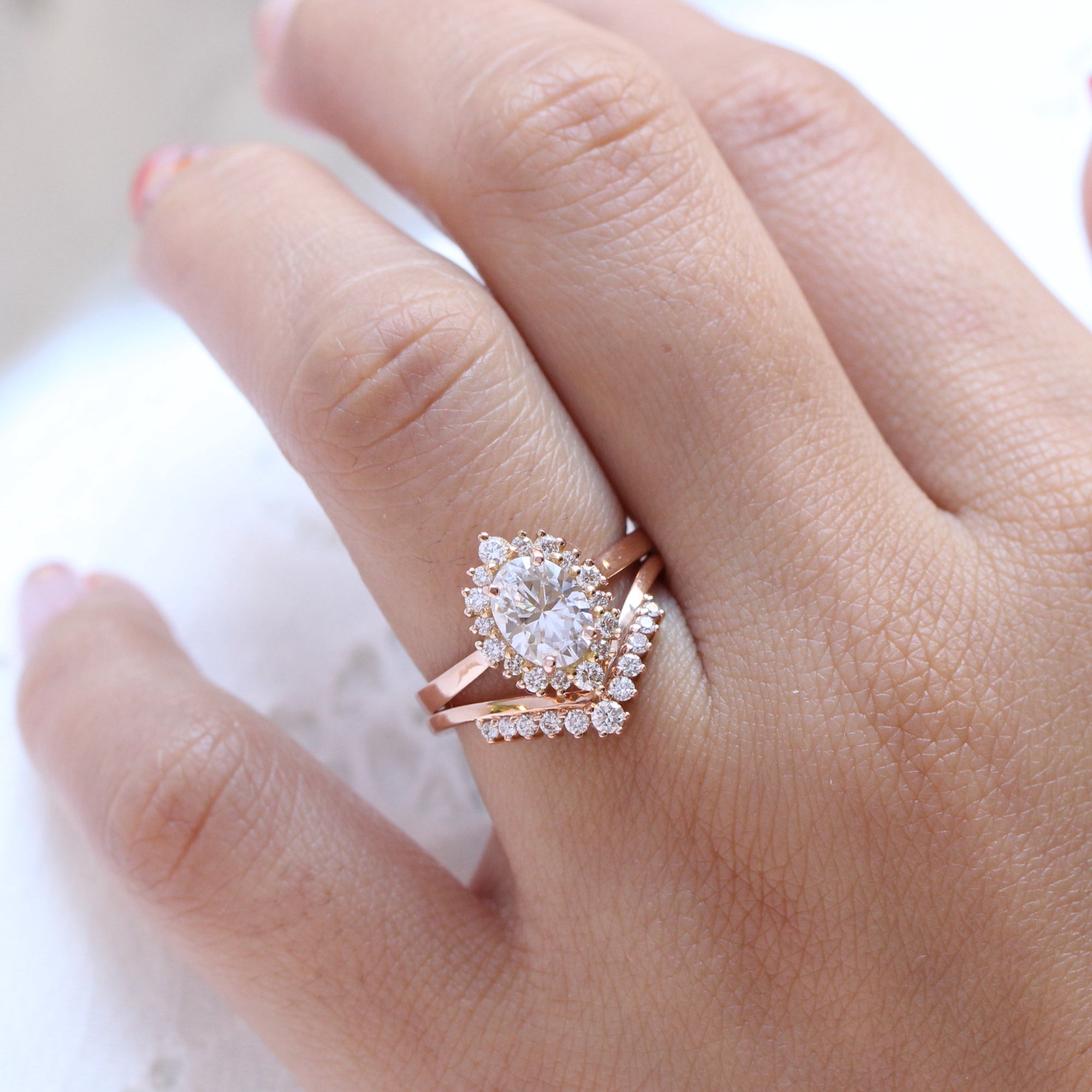 oval moissanite engagement ring rose gold halo diamond bridal set and v shaped diamond wedding band by la more design jewelry