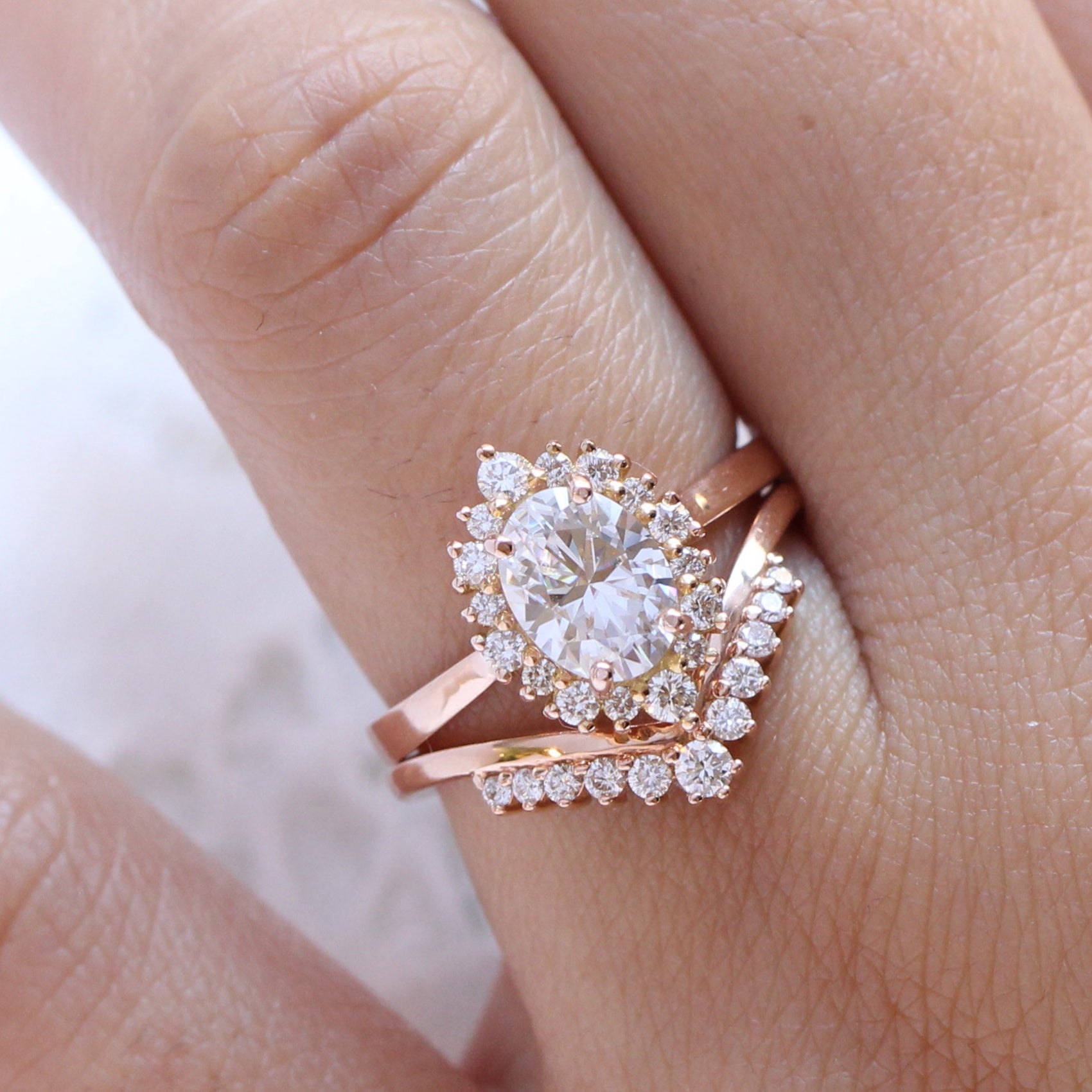 oval moissanite engagement ring rose gold halo diamond bridal set and v shaped diamond wedding band by la more design jewelry