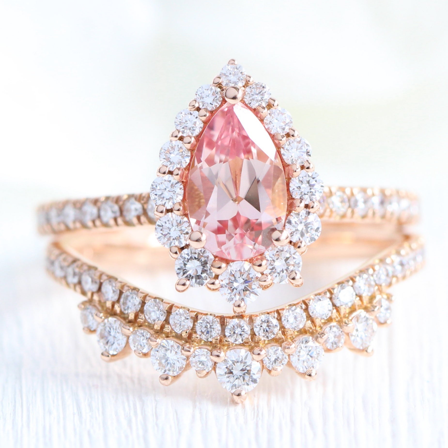 pear shaped peach sapphire engagement ring rose gold and curved crown diamond wedding band by la more design jewelry