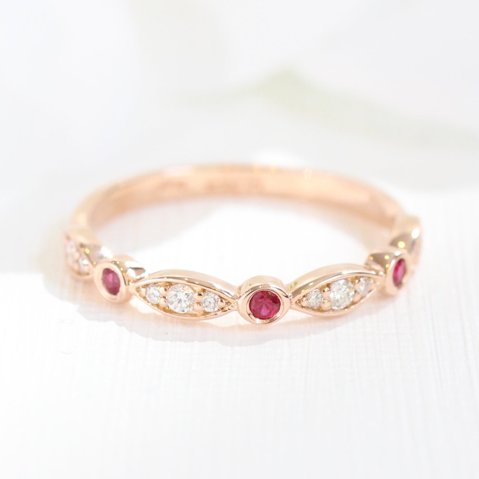 ruby and diamond wedding ring in rose gold bezel set half eternity wedding band by la more design jewelry