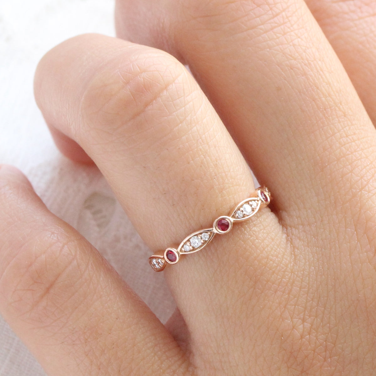 ruby and diamond wedding ring in rose gold bezel set half eternity wedding band by la more design jewelry