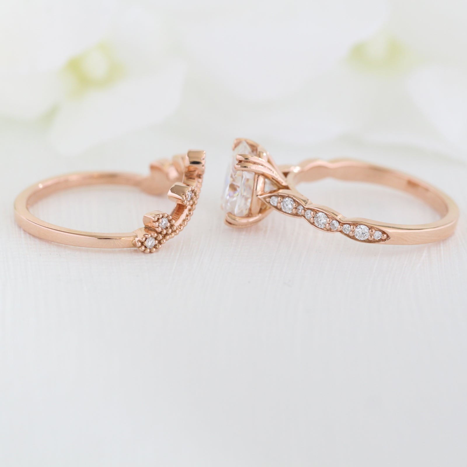 oval moissanite solitaire ring and curved leaf diamond wedding band in rose gold bridal set by la more design jewelry 