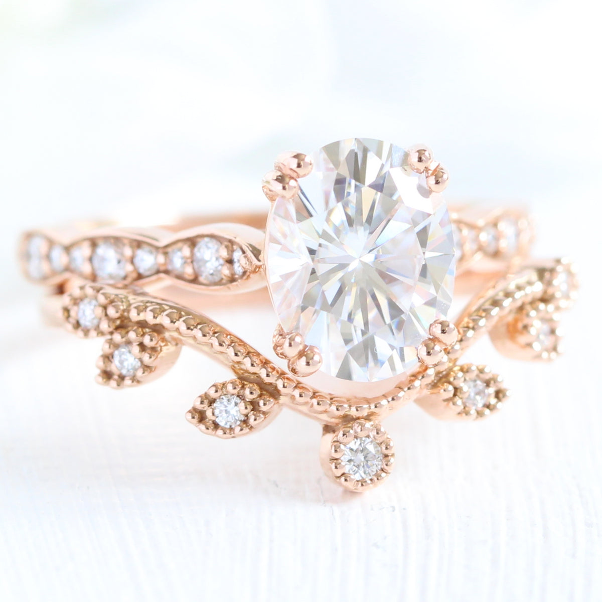 solitaire moissanite ring bridal set in rose gold curved leaf diamond band by la more design jewelry