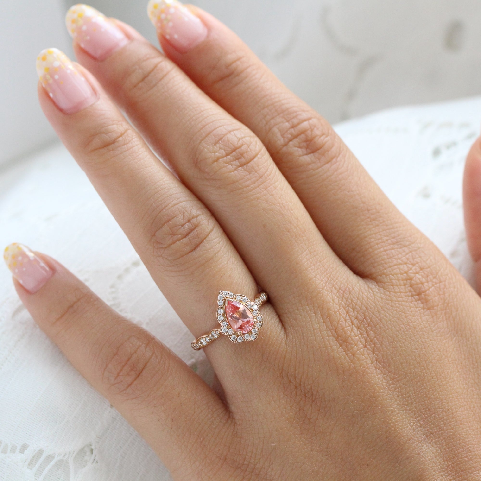 vintage inspired peach sapphire pear engagement ring in rose gold curved diamond band by la more design jewelry