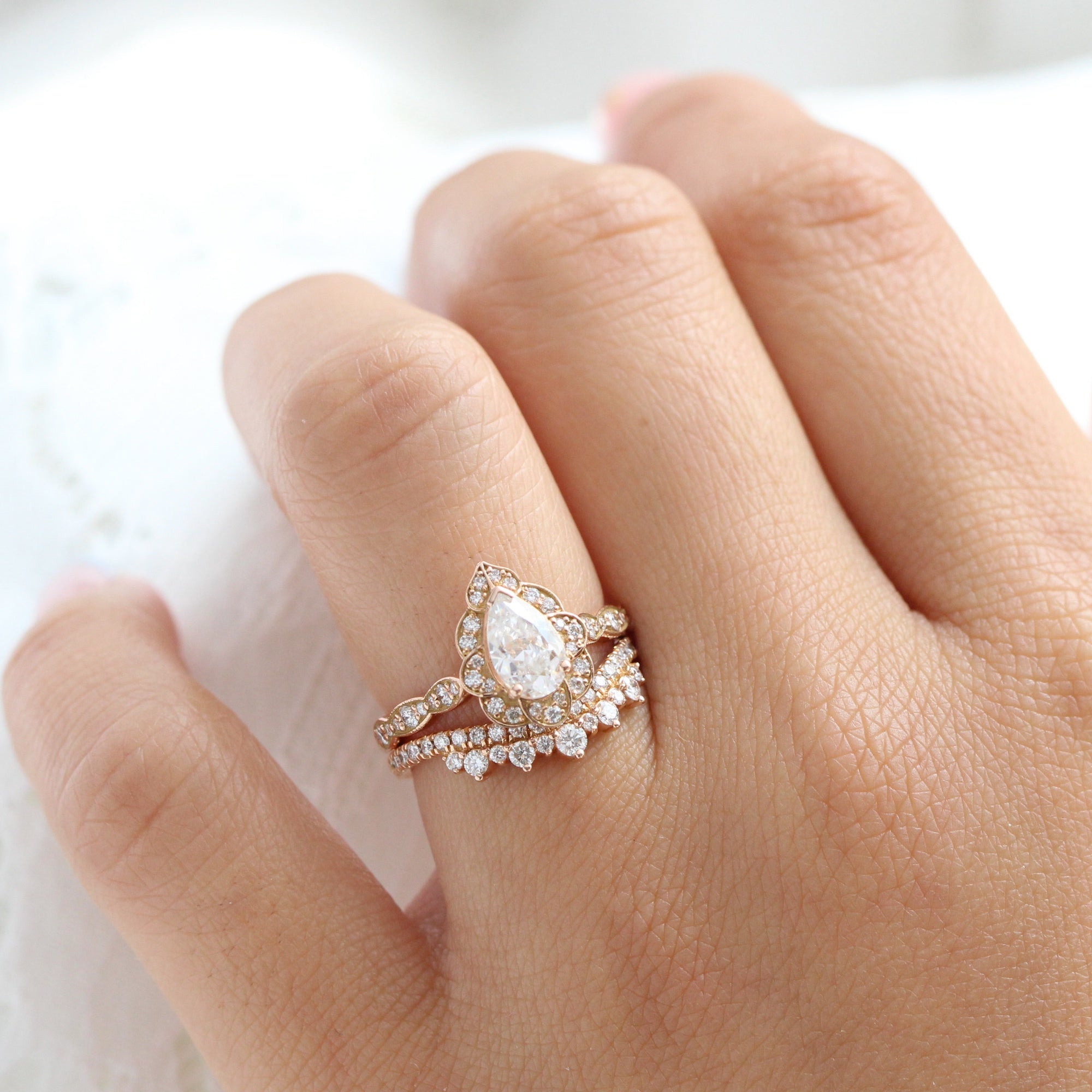 vintage inspired pear moissanite ring and crown diamond wedding band in rose gold bridal set by la more design jewelry