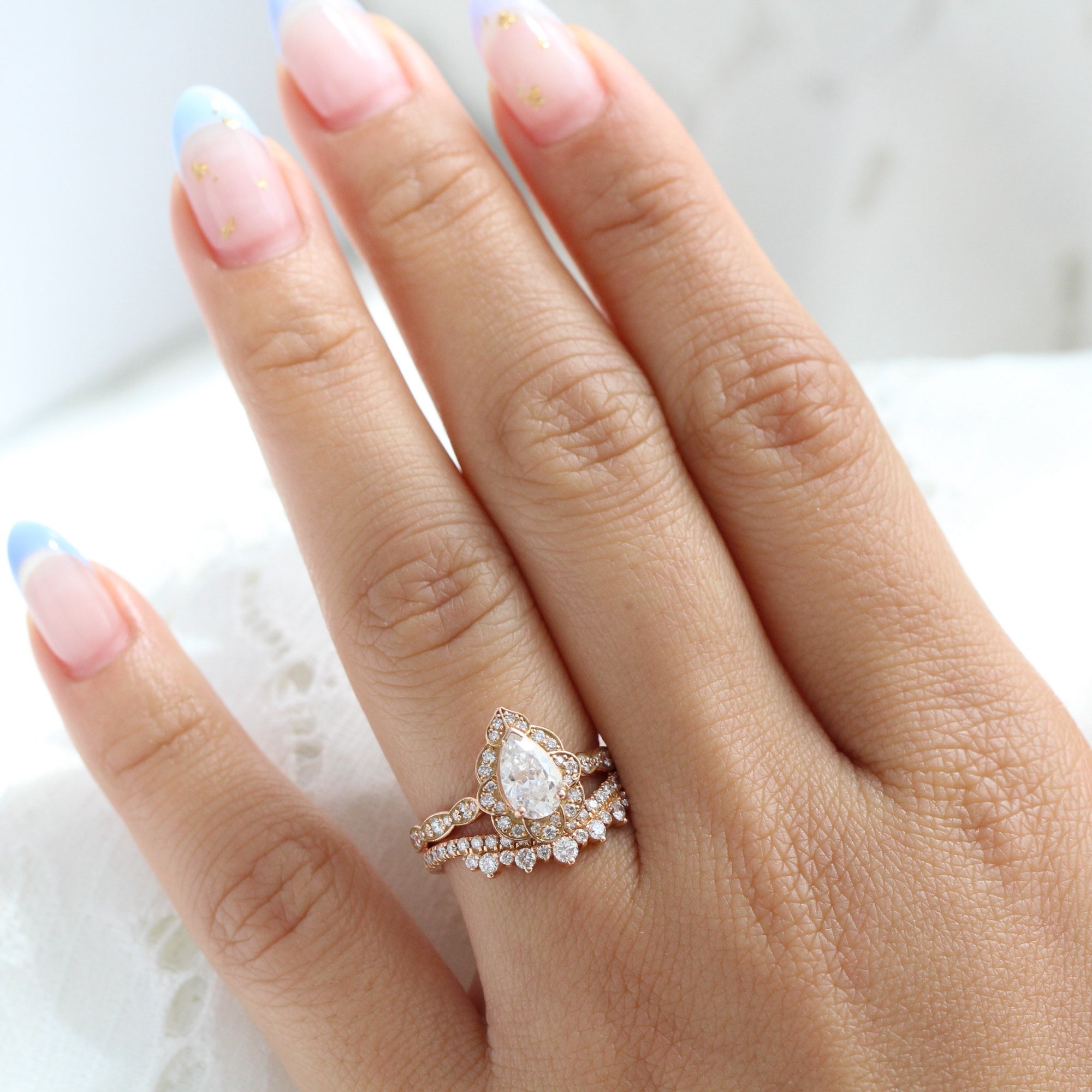 vintage inspired pear moissanite ring and crown diamond wedding band in rose gold bridal set by la more design jewelry