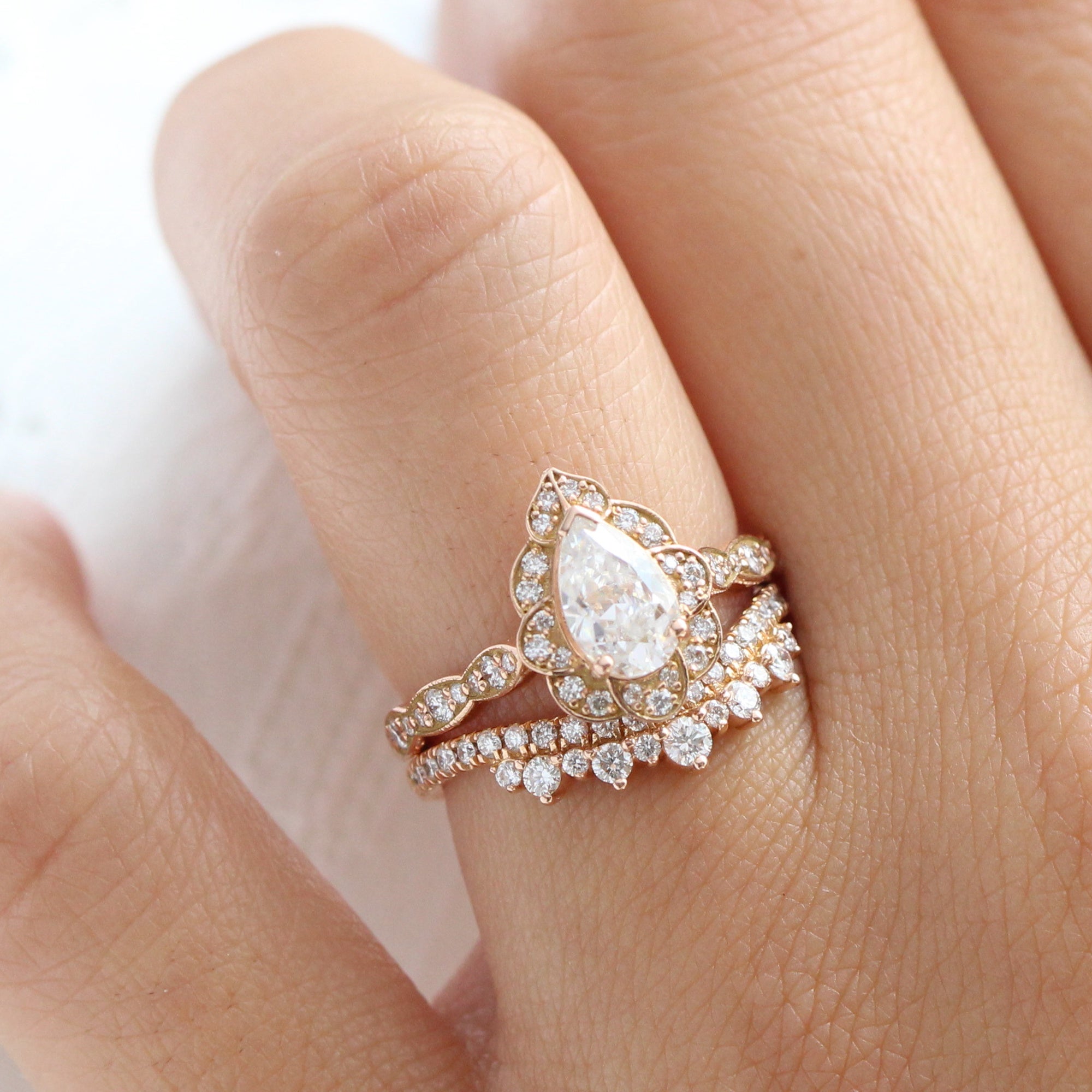 vintage inspired pear moissanite ring and crown diamond wedding band in rose gold bridal set by la more design jewelry
