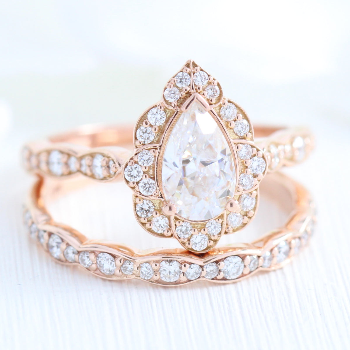 vintage inspired pear moissanite ring and matching diamond wedding band in rose gold bridal set by la more design jewelry