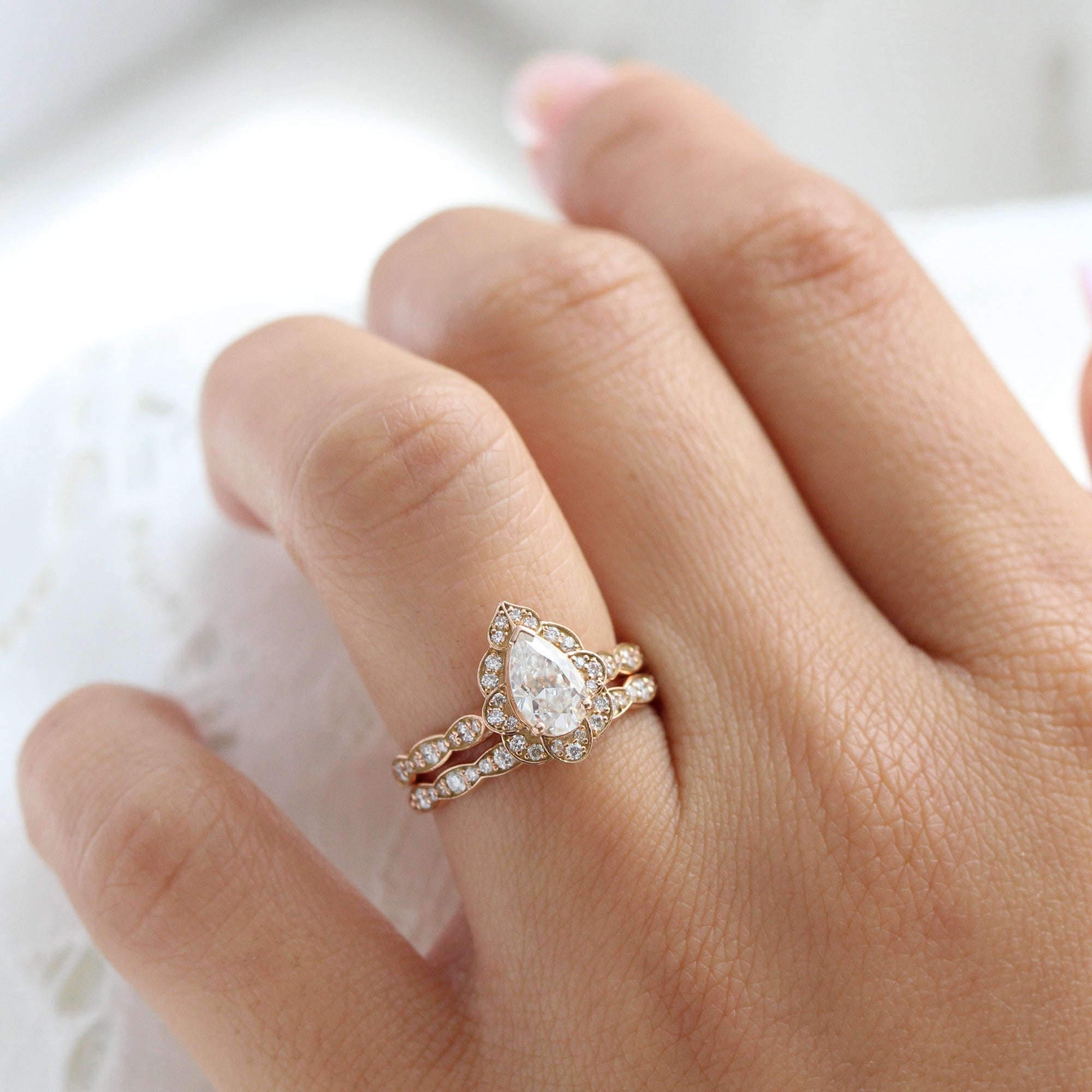 vintage inspired pear moissanite ring and matching diamond wedding band in rose gold bridal set by la more design jewelry