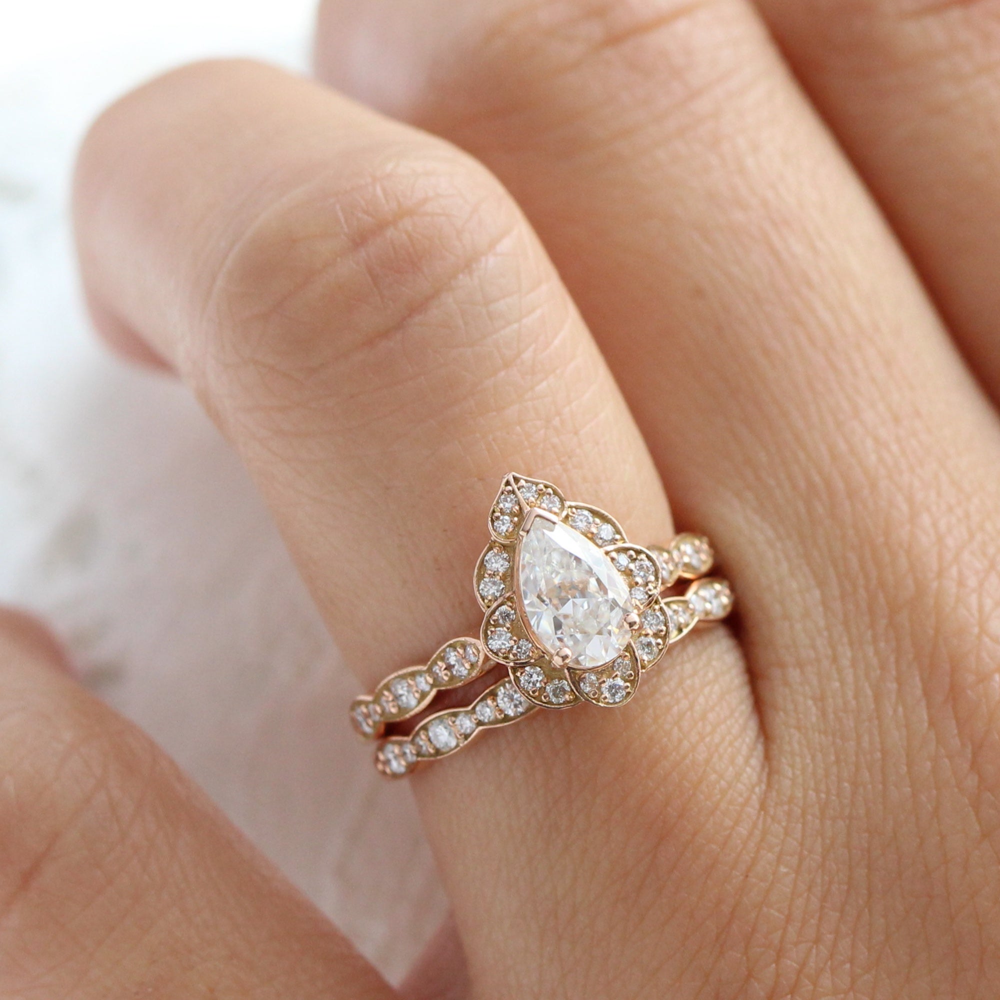 vintage inspired pear moissanite ring and matching diamond wedding band in rose gold bridal set by la more design jewelry